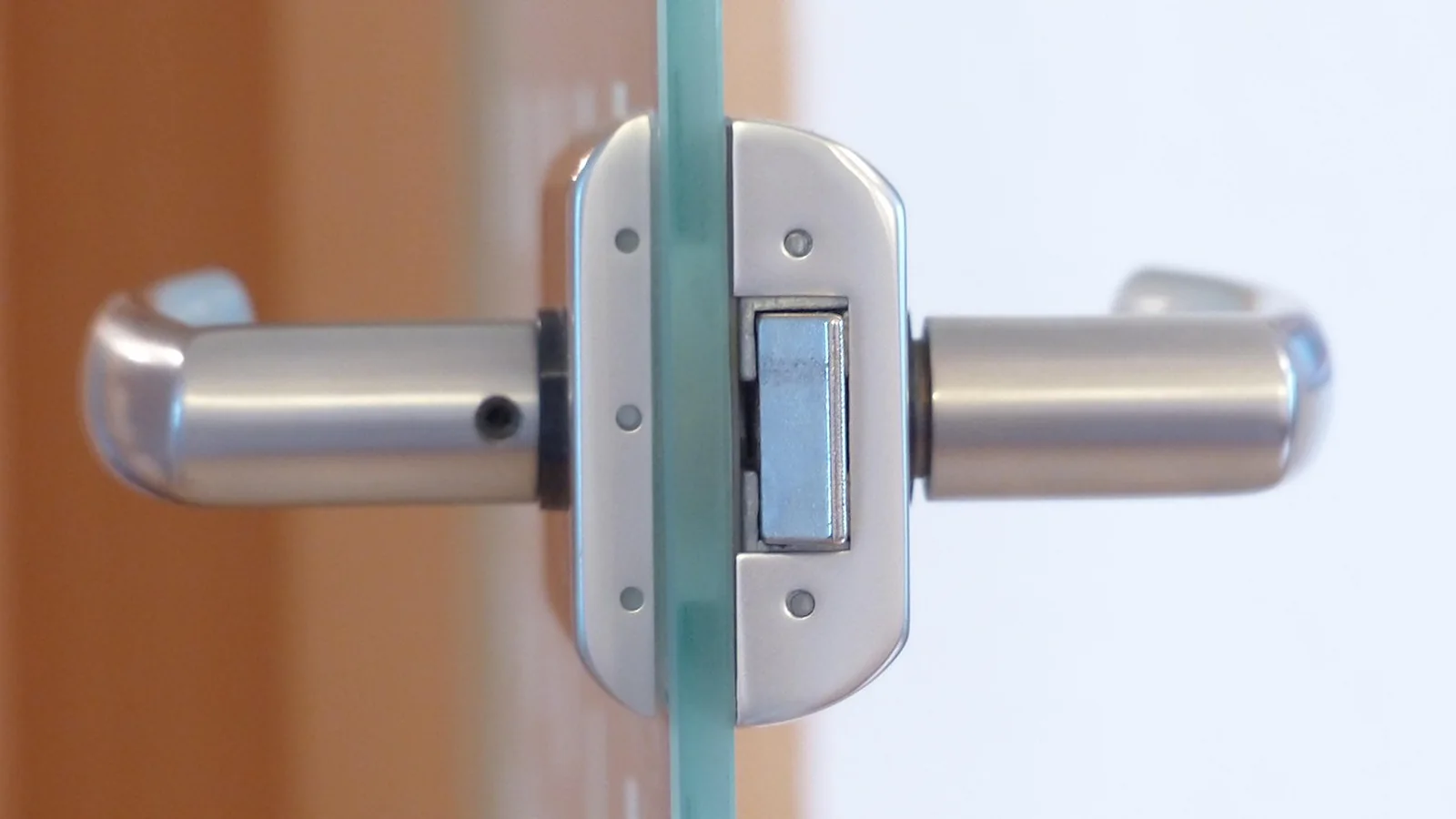 Stainless steel lever handle and lock on a glass office door