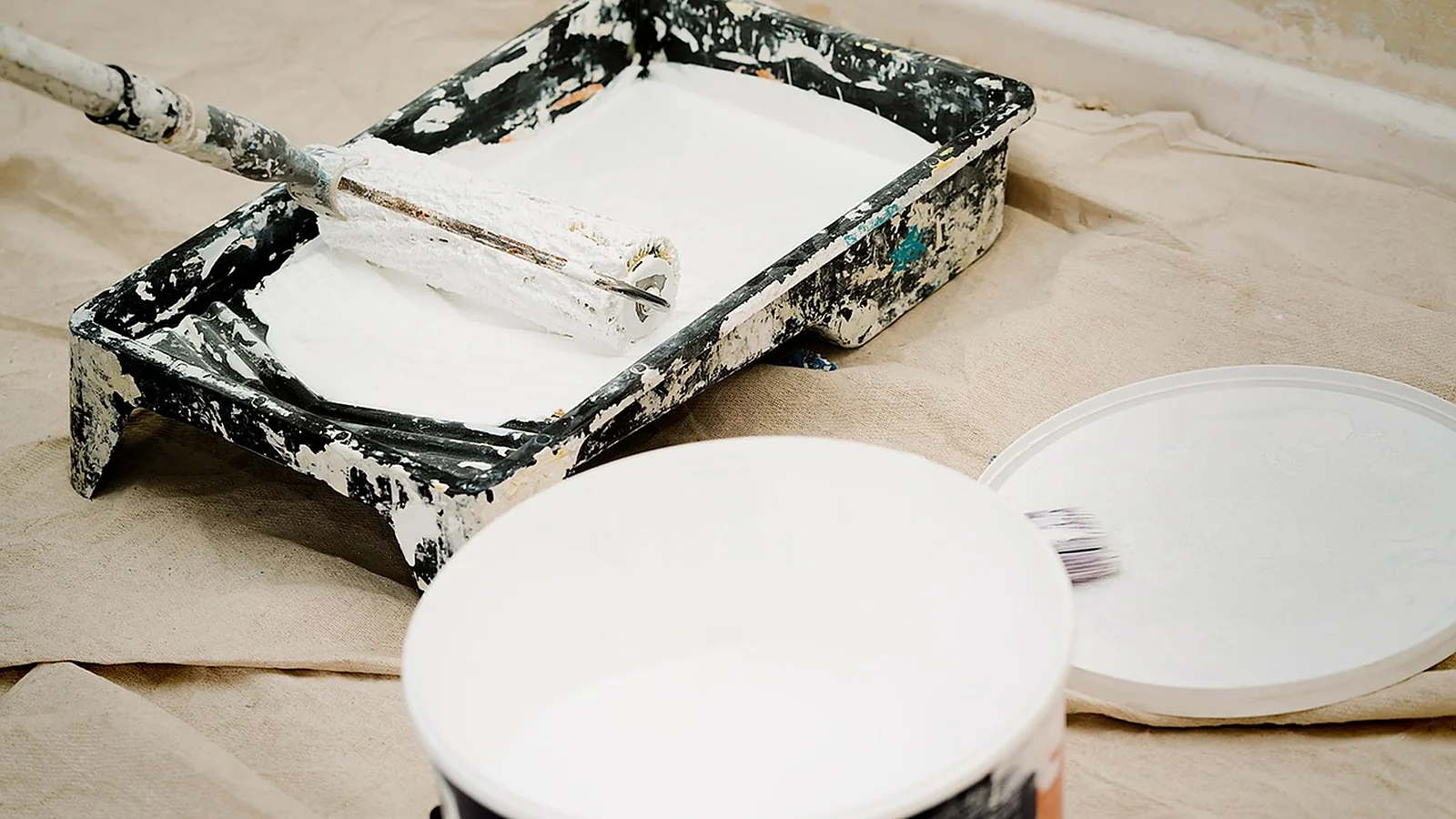 Paint roller and tray on a drop cloth during interior painting