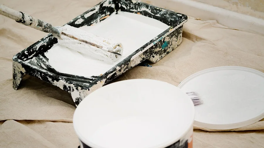 Paint roller and tray on a drop cloth during interior painting